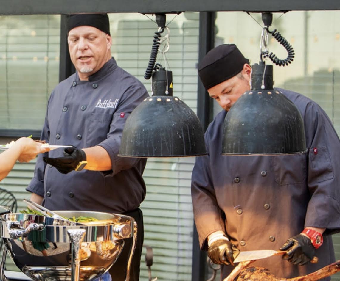 Chefs plating dishes at the reception's outdoor culinary station