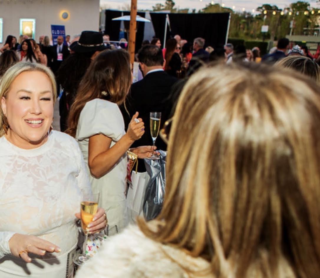 Guest laughing with champagne in hand at the outdoor evening reception