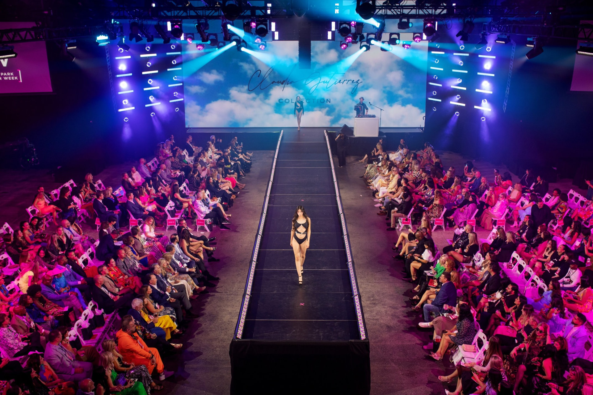 Overhead view of the packed Full Sail Live venue, guests lining both sides of the lit runway during the Claudia Gutierrez Collection