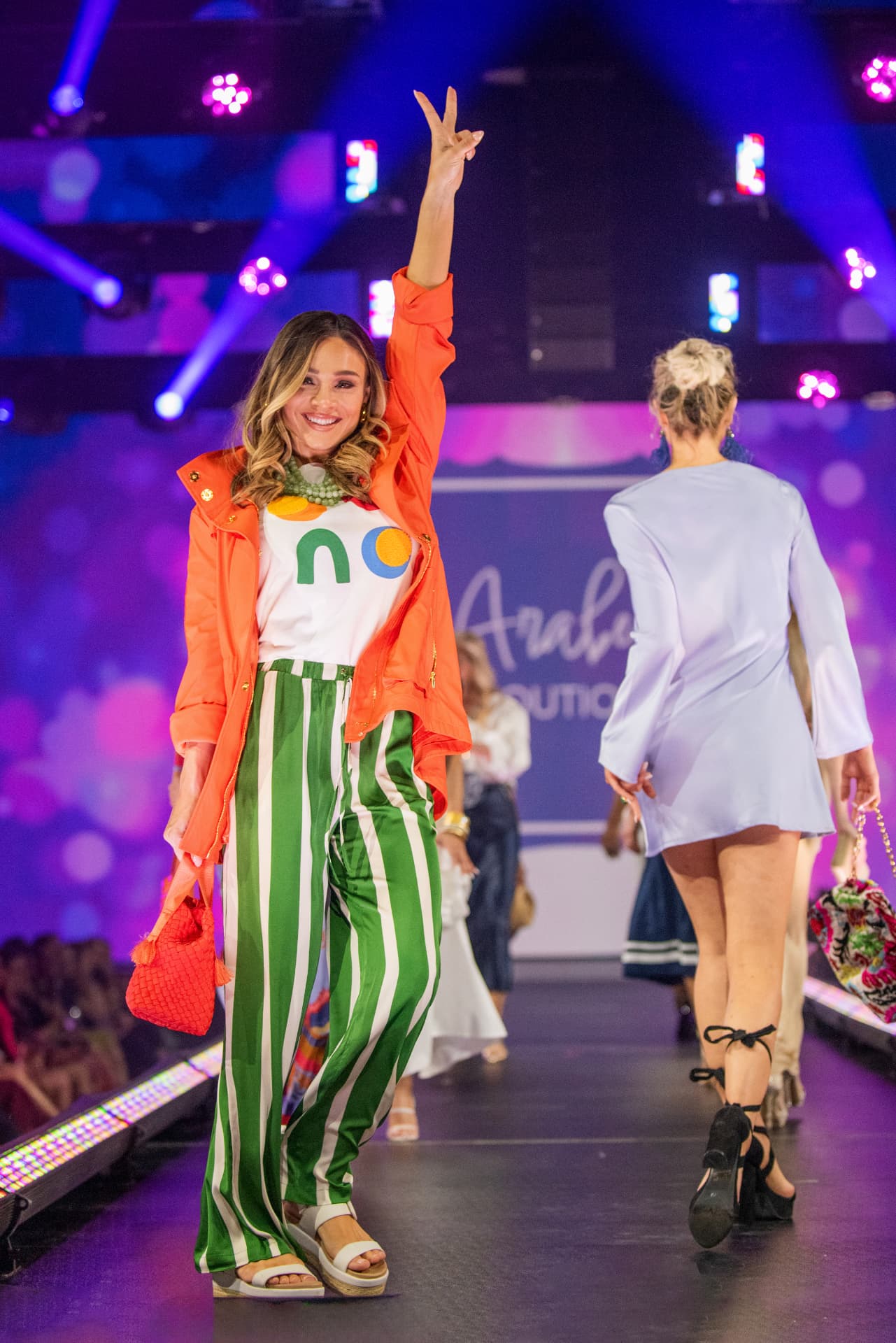 Model in orange and green on the runway