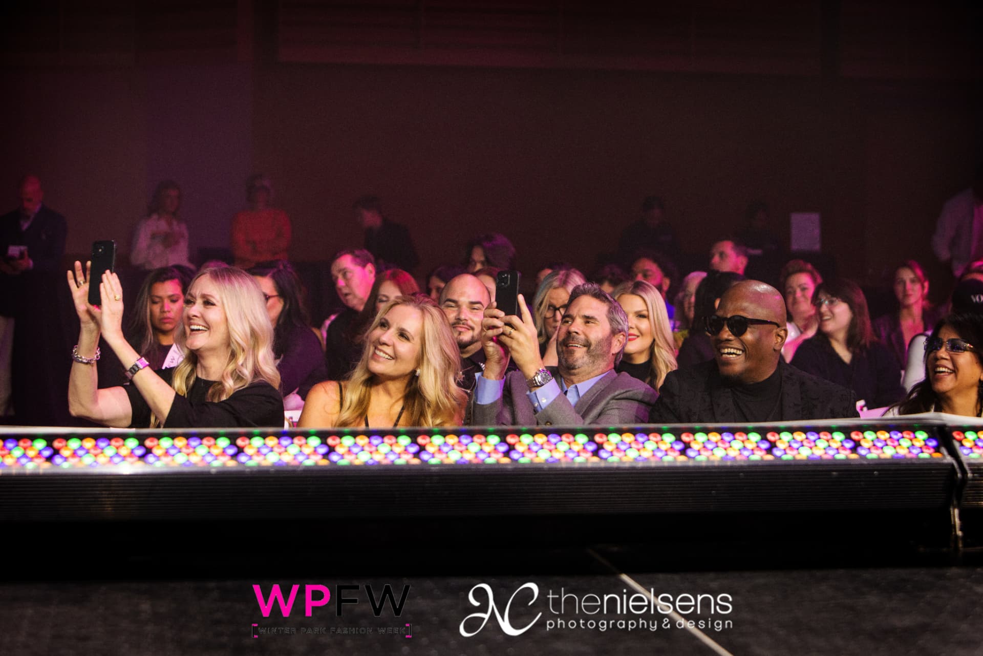 Front-row guests watching the show from above the runway's LED footlights